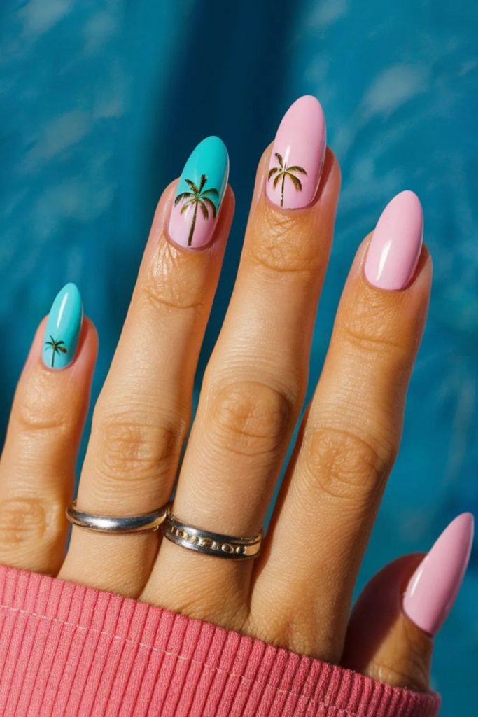 hands showing light pink summer nails featuring pink nails and blue nails with palm tree design