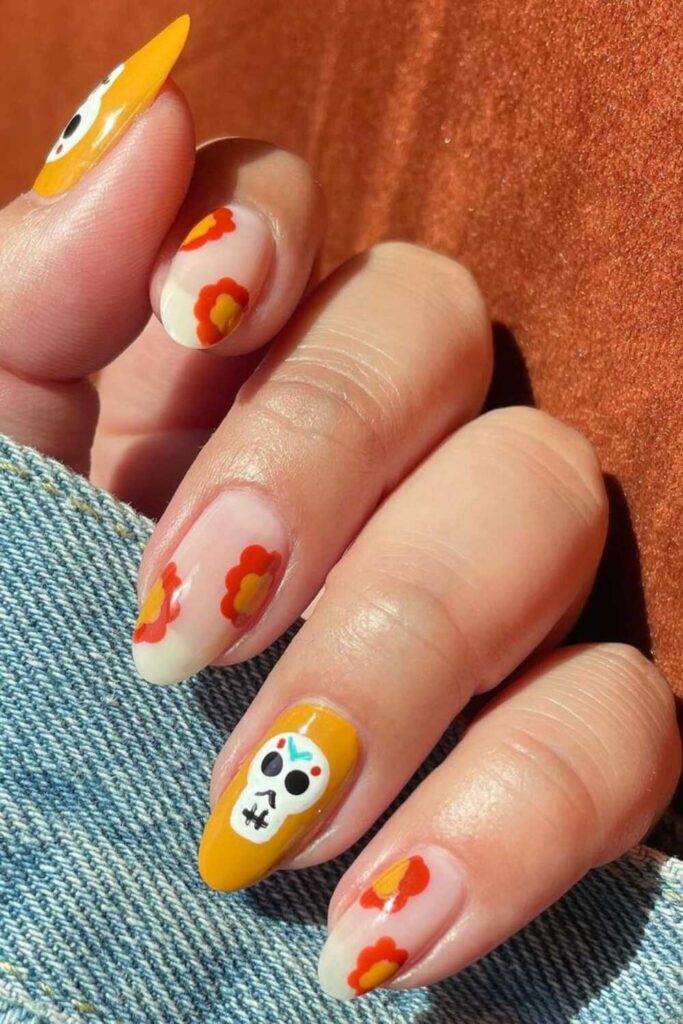 Dia De Los Muertos nails adorned with skulls and Cempasuchil